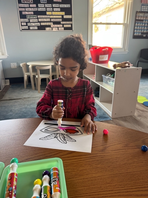 Child enjoying a colorful hands-on learning activity at Love2Learn Early Learning Center